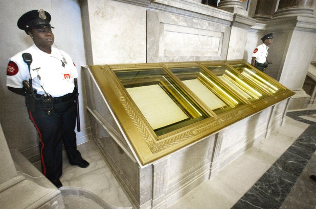 Guards stand next to the US Constitution in the Rotunda of the National Archives in Washington.